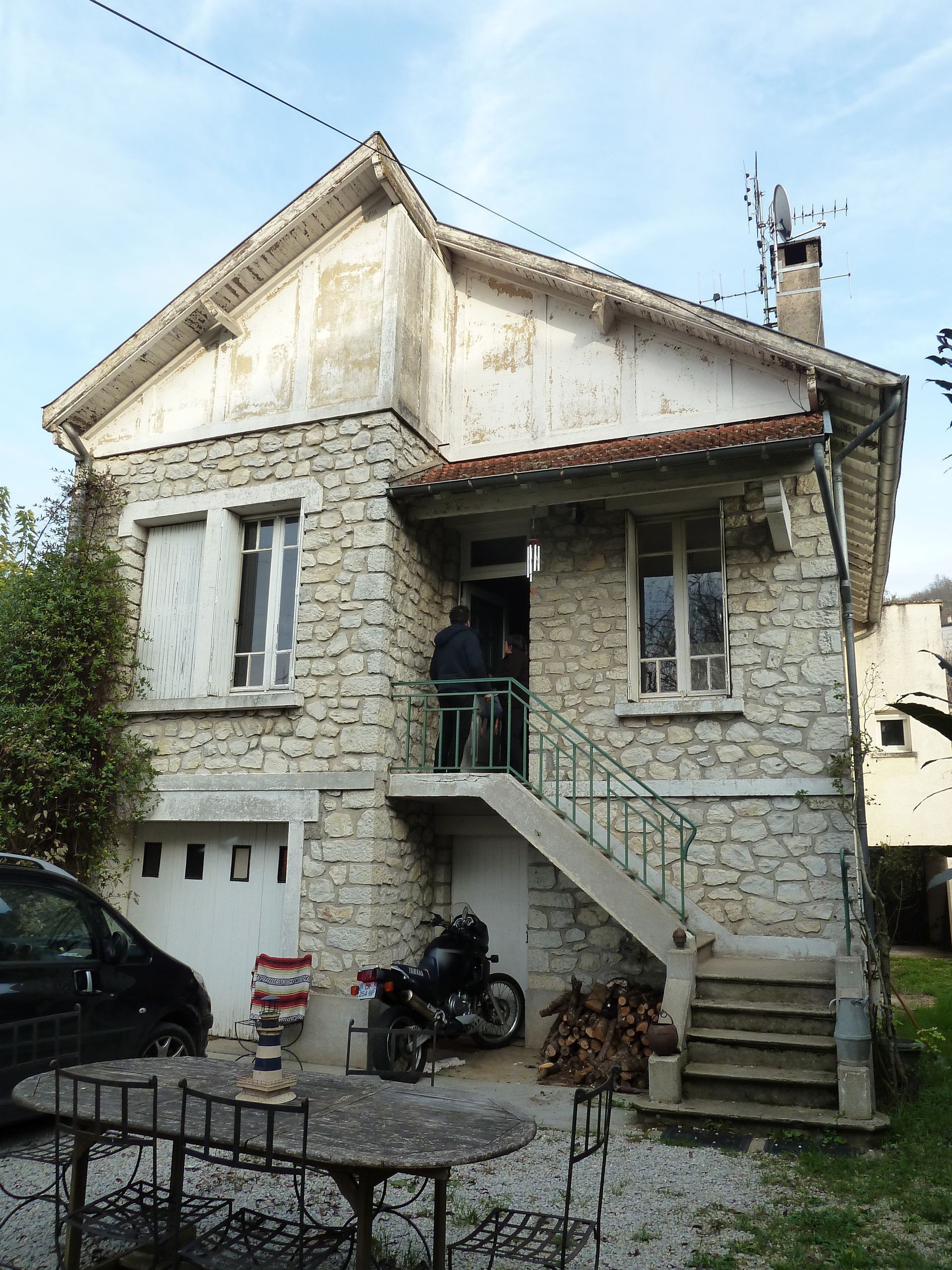 Mur partiellement nettoyé, laissant apparaître le contraste entre la moisissure noire et le stuc blanc.