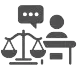 Persona en un escritorio hablando junto a una balanza de la justicia.