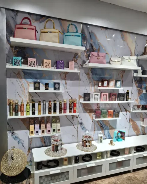 Colección de cajas de perfume en varios colores; algunas doradas, amarillas, naranjas, rosas, negras.