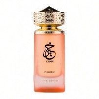 Un frasco de perfume con tapón dorado y cuerpo color melocotón; el frasco tiene texto en árabe.