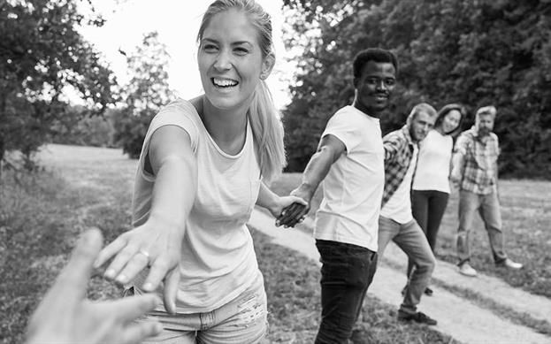 Team von Pflegedienst macht Menschenkette im Park