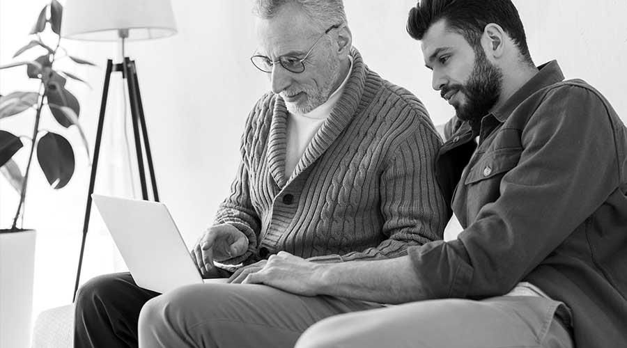 Sohn liest mit Vater auf Laptop