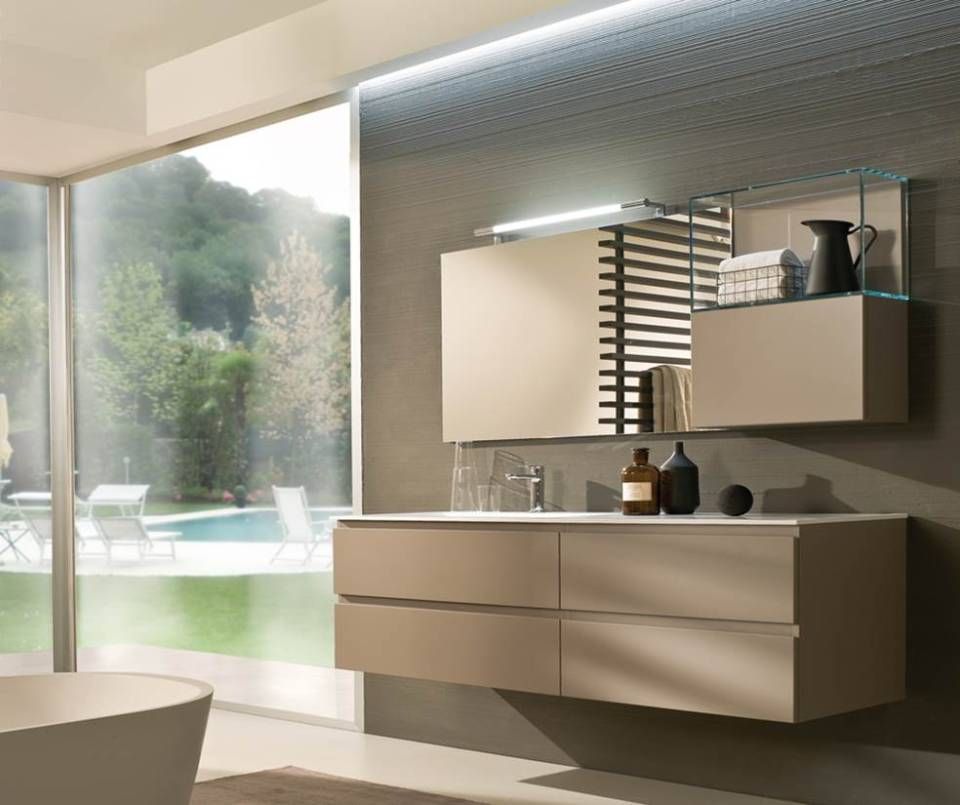 Ein moderner, minimalistischer Badezimmerwaschtisch in sanftem Beige mit Schubladen, einem Wandschrank und einem Spiegel vor einer grauen Wand.