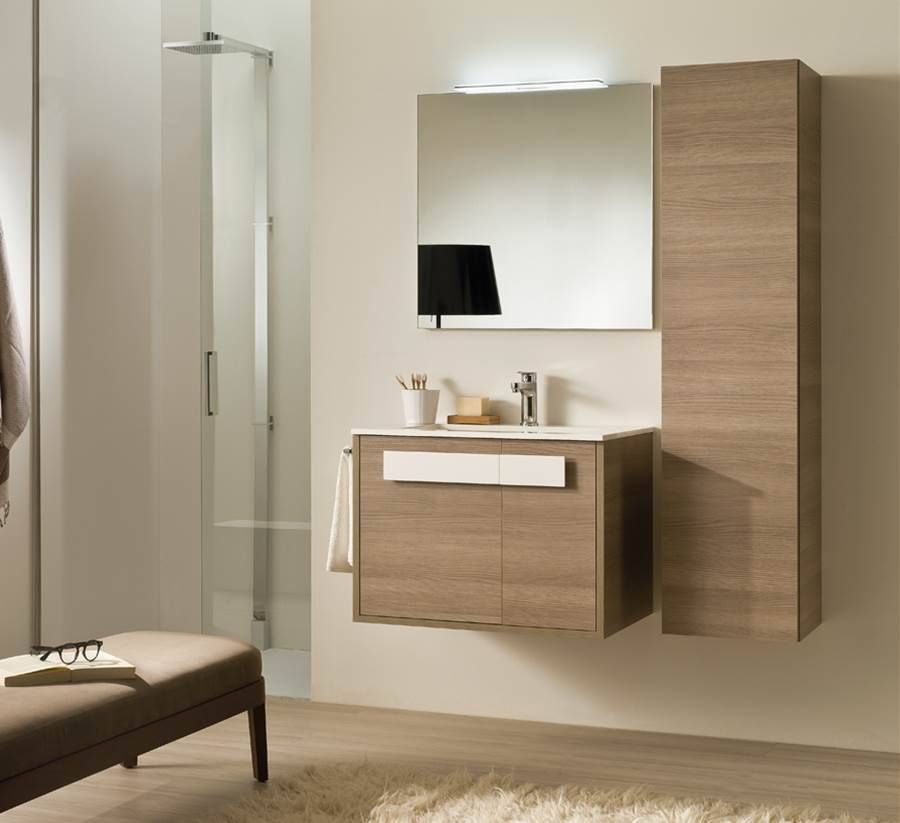 Ein an der Wand montierter Waschtisch aus Holz mit Spiegel, Waschbecken und hohem Schrank vor einer Wand in neutralen Farbtönen.