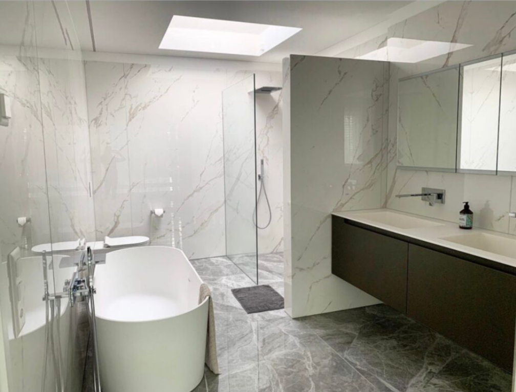 Nahaufnahme einer dunkelgrauen Marmorfliese mit feinen, hellen, netzartigen Adern.