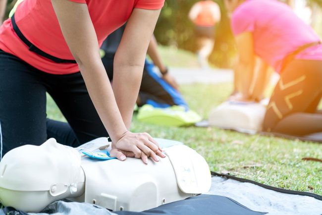 Personne en train de se forme au massage cardiaque sur un mannequin