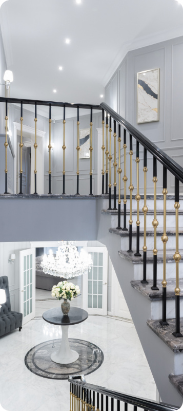 Entrée de maison luxueuse avec un grand escalier et un lustre.