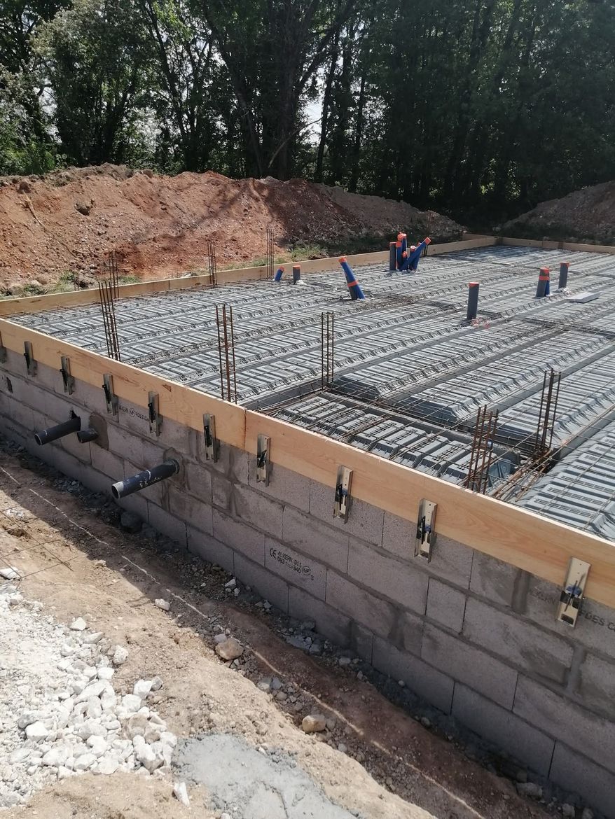 Un maçon utilise une truelle pour appliquer le mortier entre les briques d'argile lors de la construction d'un mur.