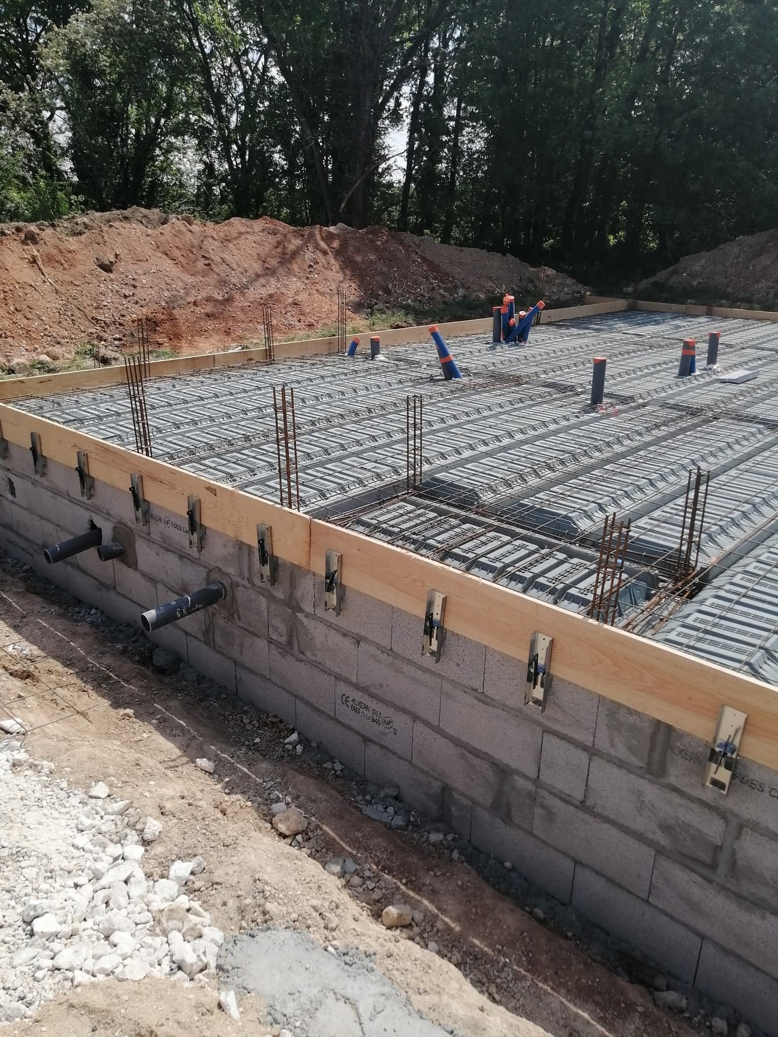 Un maçon utilise une truelle pour appliquer le mortier entre les briques d'argile lors de la construction d'un mur.