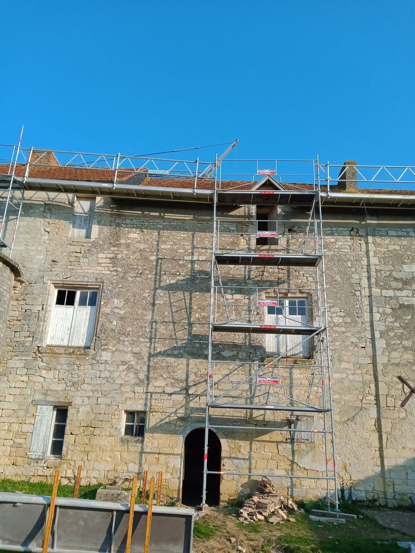Gros plan sur une main posant une brique blanche sur un lit de mortier, le long d'un fil de guidage, pour un projet de construction.