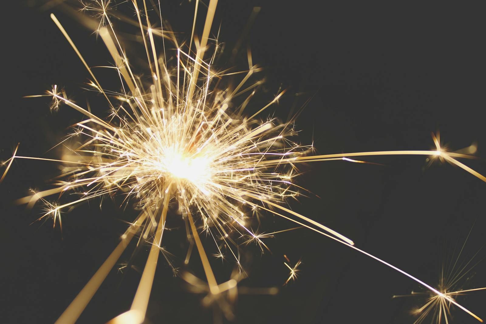 a handheld sparkler glowing with golden sparks against a dark background, symbolising the moment of reclaiming identity after a late ADHD and autism diagnosis