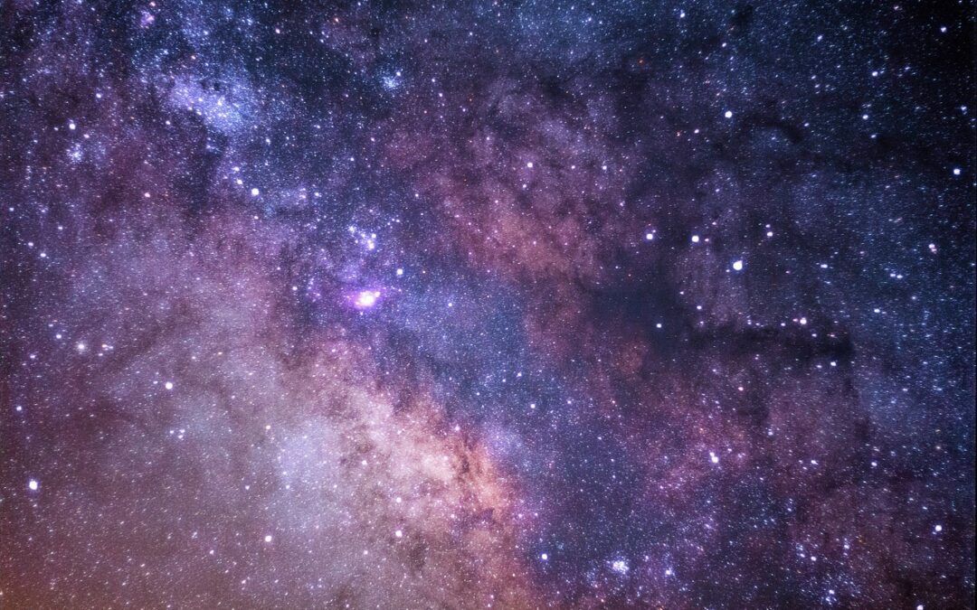 a night sky showing the Milky Way with the silhouettes of trees in the foreground, representing the balance between the grounded and expansive inner world of women with AuDHD
