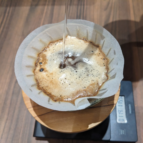 Eine Tasse Kaffee wird in einen Papierfilter gegossen