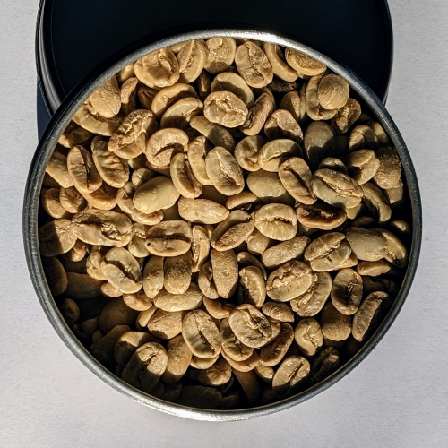 Eine Metalldose gefüllt mit Erdnüssen auf einer weißen Oberfläche