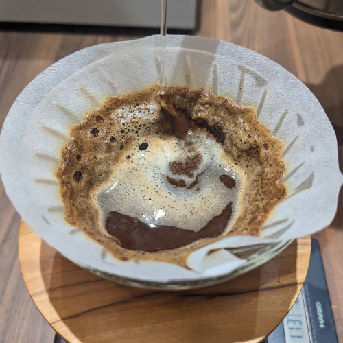 Eine Tasse Kaffee wird durch einen Papierfilter gegossen