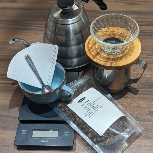 Eine Tüte Kaffeebohnen liegt auf einem Tisch neben einer Waage.