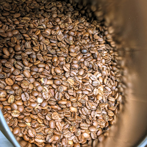 Ein Haufen Kaffeebohnen in einem Metallbehälter