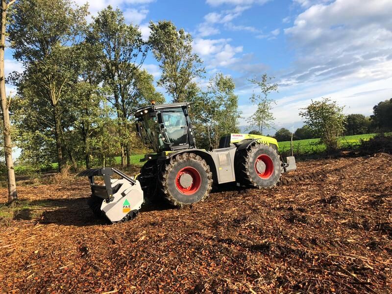 Ein Traktor fährt durch einen Mulchhaufen auf einem Feld.