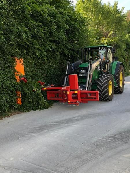 Ein grün-gelber Traktor steht am Straßenrand.