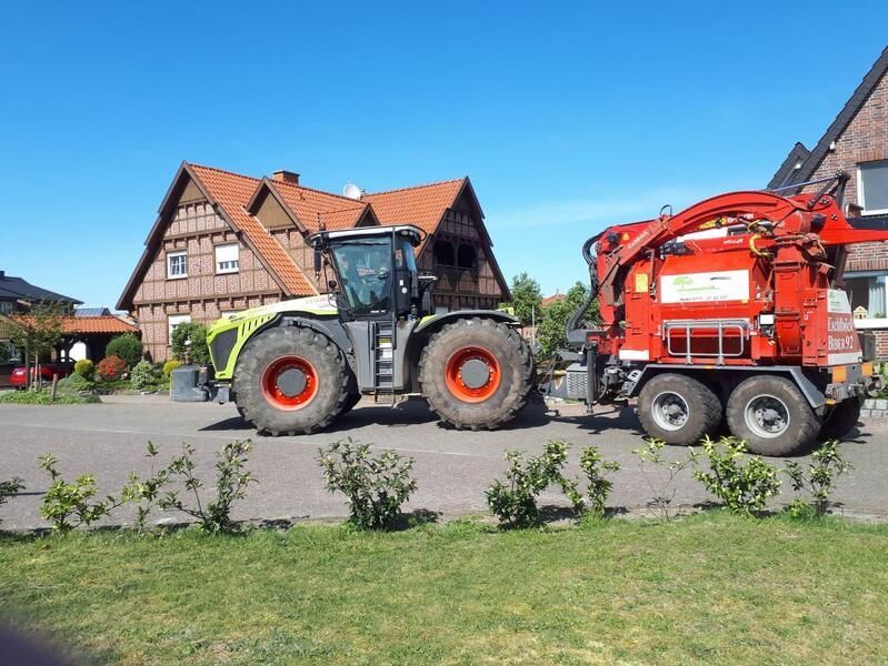 Zwei Traktoren stehen vor einem Haus