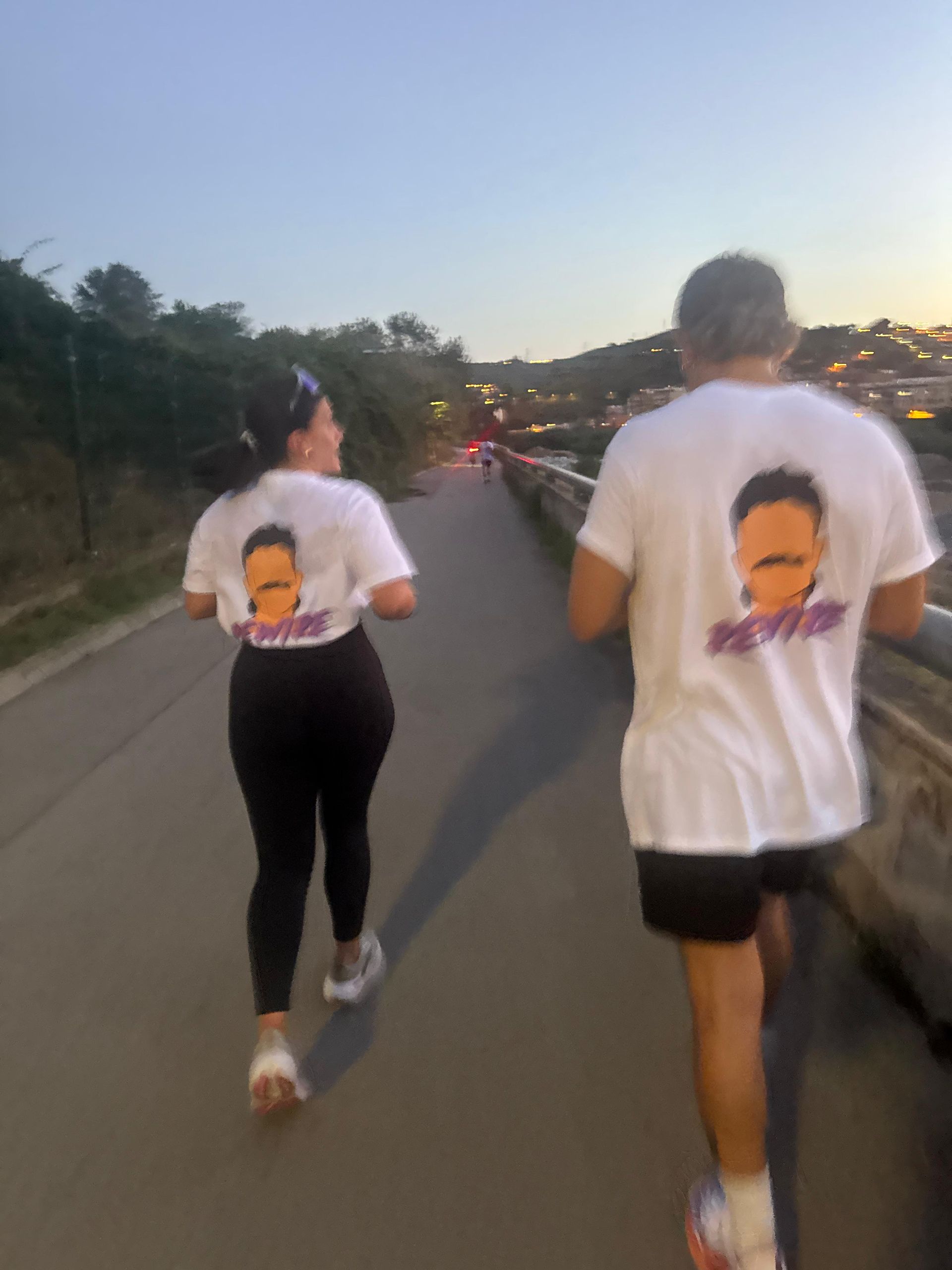 Dos personas corriendo por un sendero, vistiendo camisetas blancas