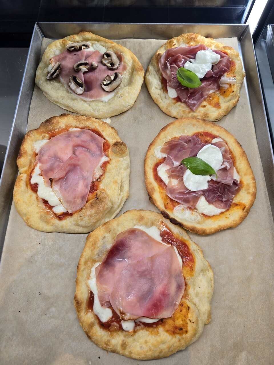 Un plateau de pizzas avec différentes garnitures dessus