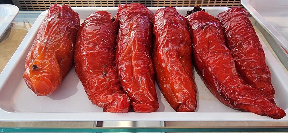 Un plateau de poivrons rôtis sur une étagère en verre