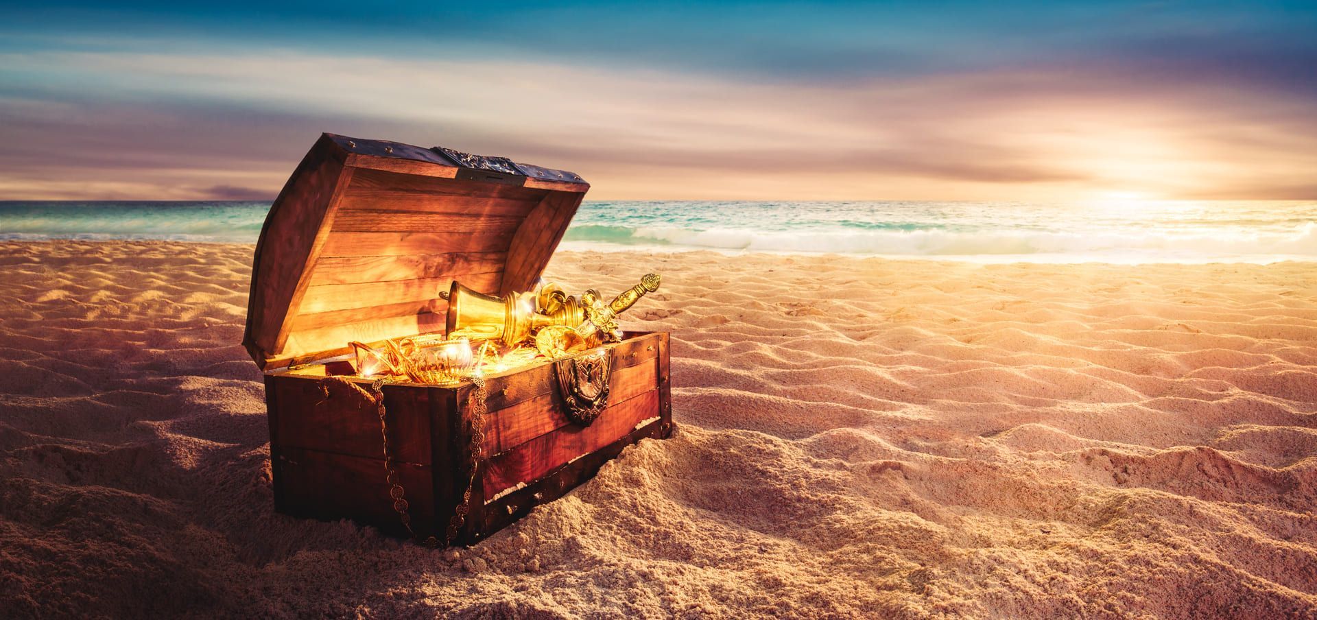 Eine mit Gold gefüllte Schatztruhe steht an einem Sandstrand | Beate Hackmann Unternehmensberatung