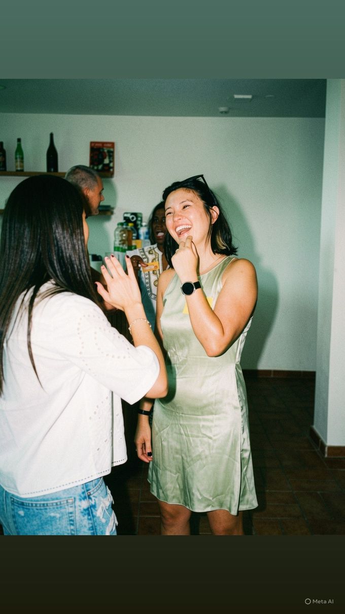 Amigos riendo y bailando juntos en una animada fiesta en el interior de una habitación luminosa.