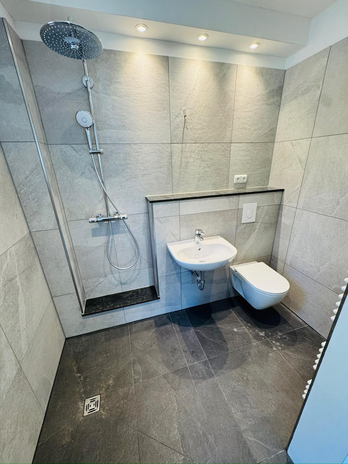 Marmorfliesen und drei Einbaudeckenstrahler als Dusche