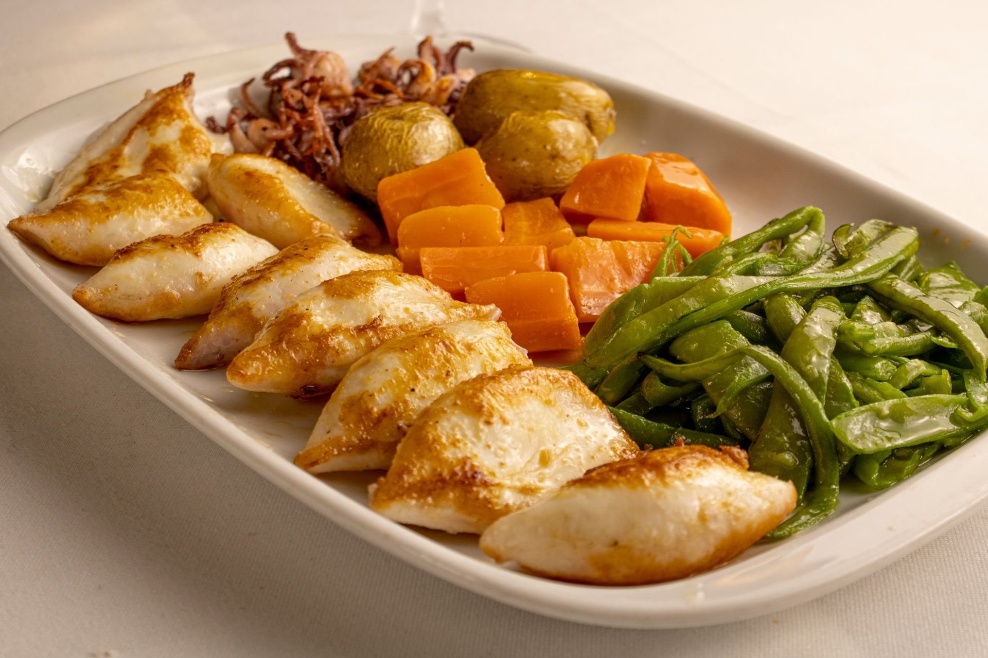 Prato de frutos do mar fritos, vegetais: cenouras, batatas, feijões.