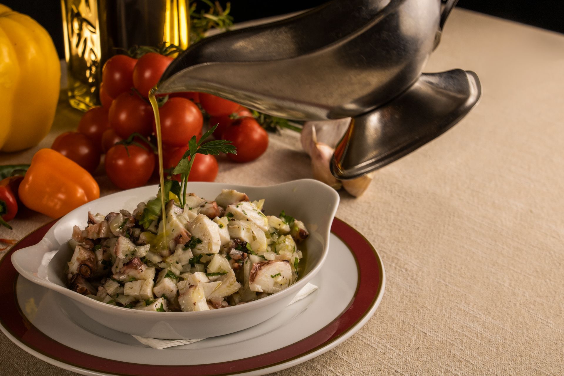 Salada de polvo regada com azeite de oliva, acompanhada de tomates e pimentões.