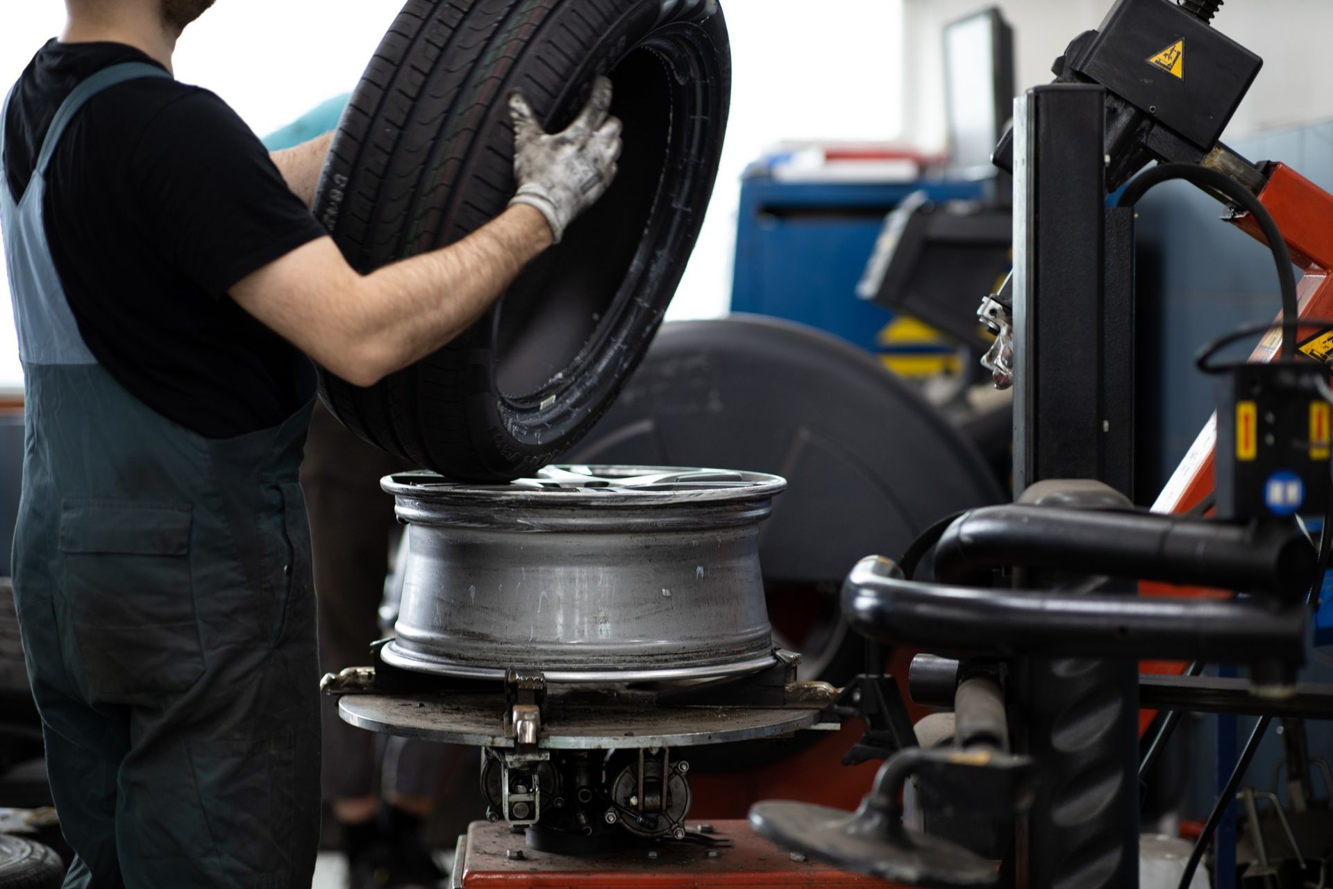 Un hombre está cambiando un neumático de una máquina en un garaje.