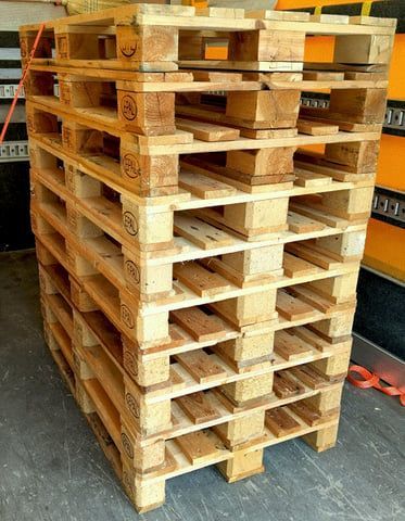 Ein Stapel Holzpaletten in einem Lagergang.