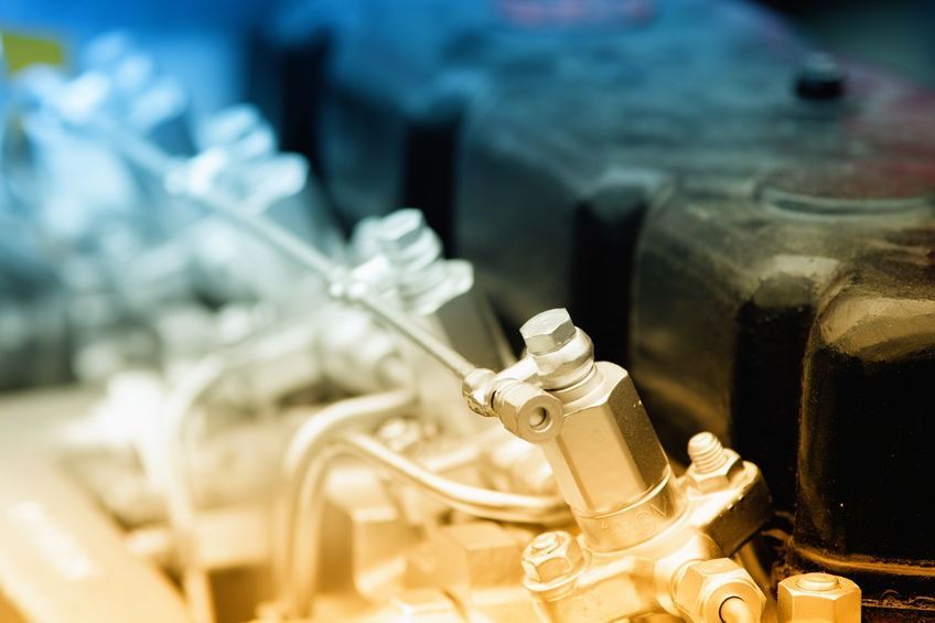 Un primer plano de un motor de automóvil del que sale humo.