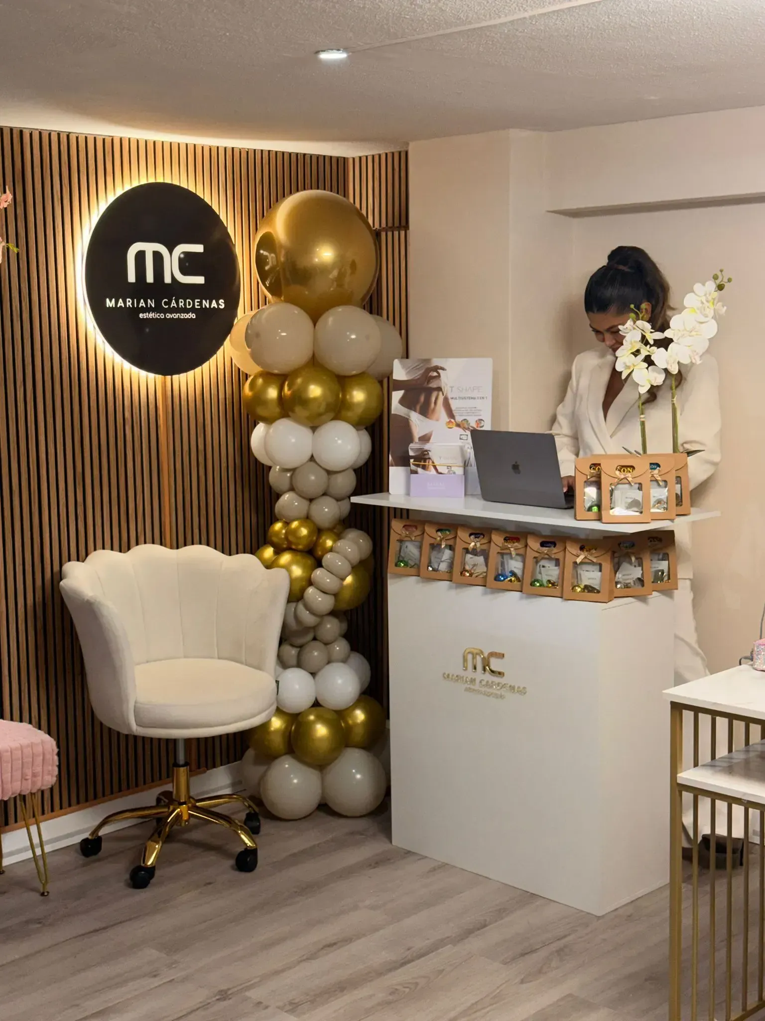 Una moderna zona de recepción con un mostrador blanco, una silla con forma de concha