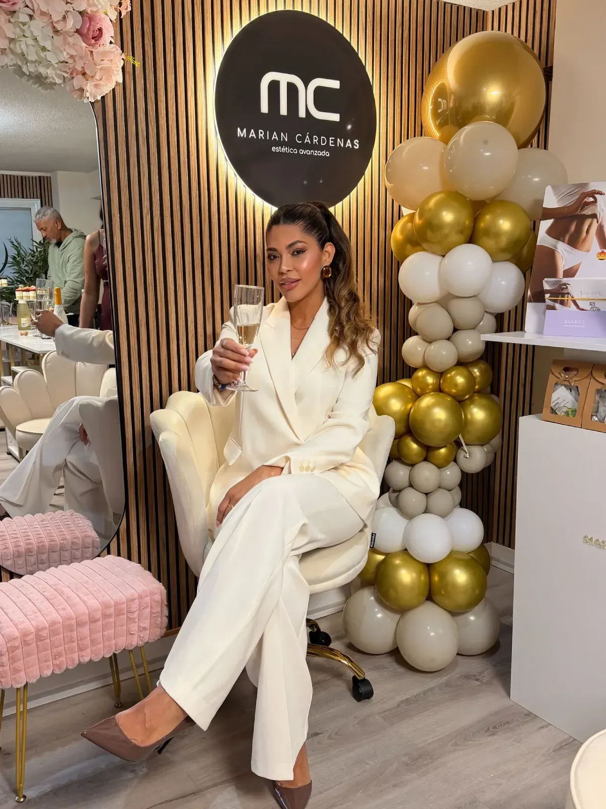 Una sala de tratamiento con una camilla de masaje blanca cubierta con una tela rosa y beige