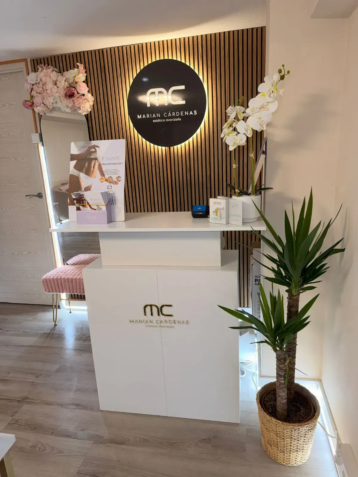 Una moderna zona de recepción con un mostrador blanco, una silla con forma de concha