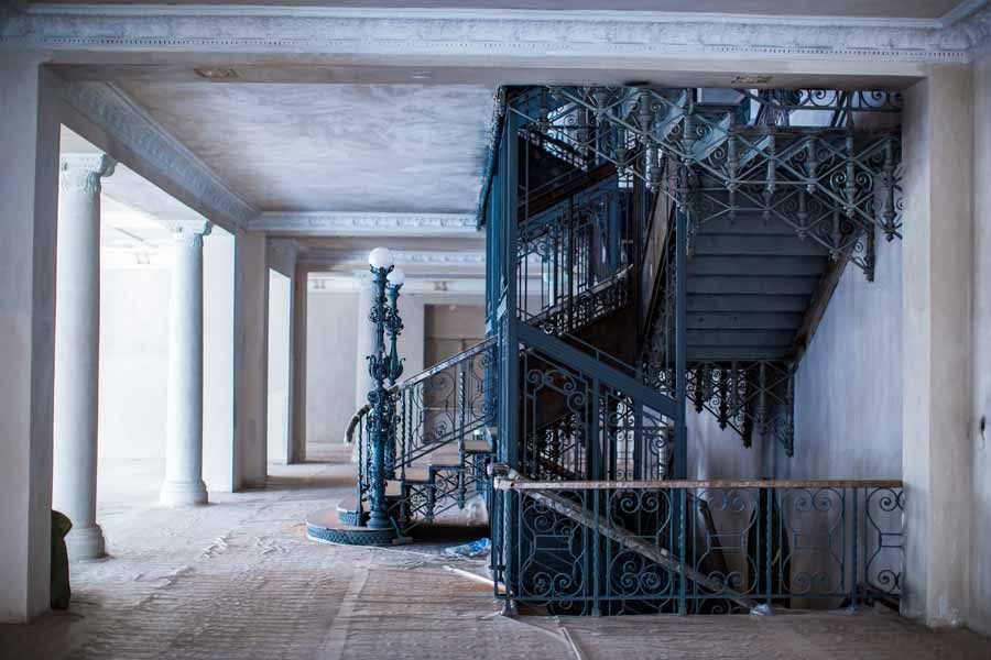 Vieil ascenseur entouré d'un grand escalier