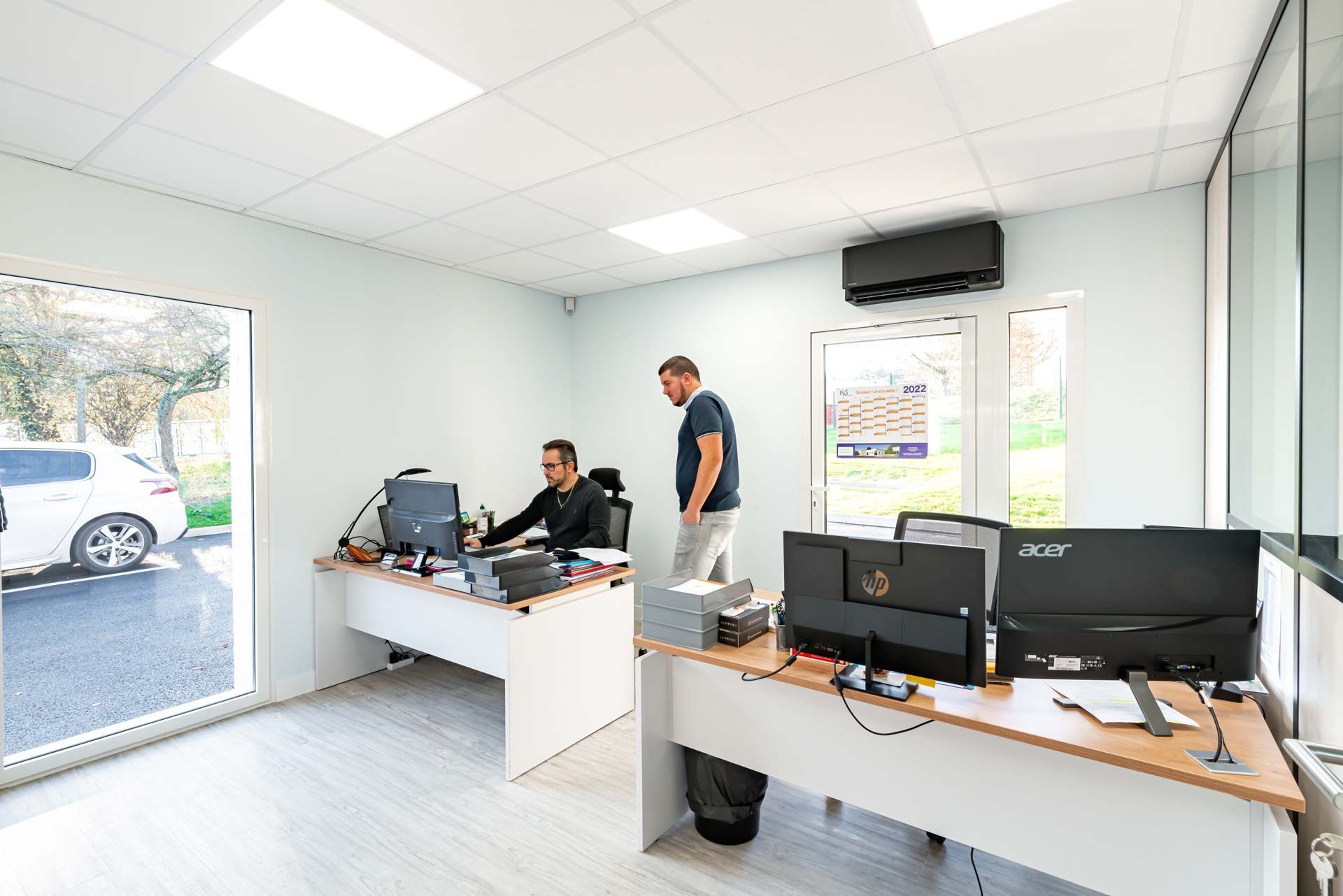 Deux personnes en train d'étudier sur un ordinateur dans les bureaux de M2S Ascenseurs