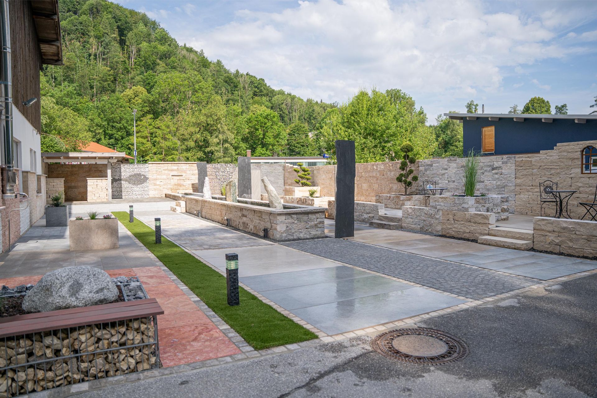 Moderne Gartenanlage mit Naturstein, Wasserfläche und klaren Linien im Außenbereich