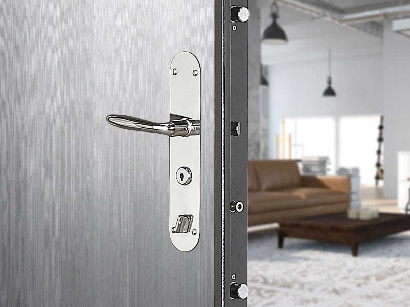 Une porte en métal argenté avec une poignée et une serrure chromées, dévoilant un espace de vie intérieur.