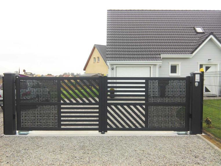 Portail d'allée en métal noir avec panneaux décoratifs ; maison en arrière-plan.