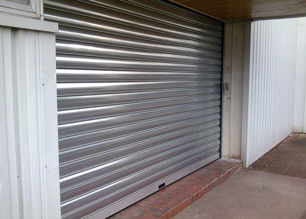 Volet roulant métallique fermé sur la façade d'un bâtiment.
