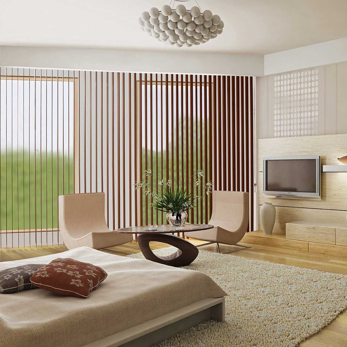 Chambre avec lit, chaises, table et télévision. Stores donnant sur le jardin. Tons beige, marron et blanc.