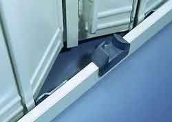 Gros plan sur une porte d'armoire bleue montée sur un cadre en métal clair avec une butée triangulaire foncée en bas.