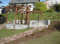 niedrige Stützmauern aus Pflasterstein mit Holzgestell auf einer Grasfläche
