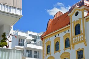 Ein weißes Gebäude mit rotem Dach ist von anderen Gebäuden umgeben