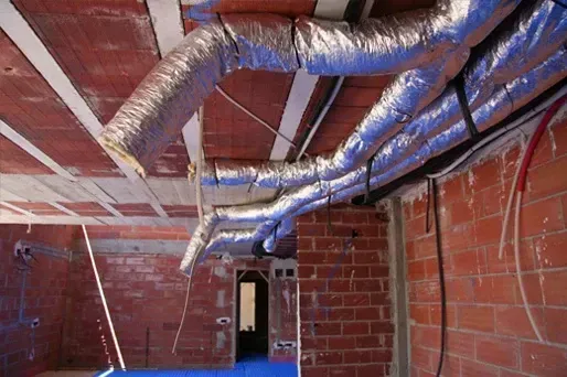 Una pared de ladrillos con un montón de tuberías saliendo de ella.