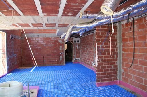 Una habitación con paredes de ladrillo y una alfombra azul en el suelo.